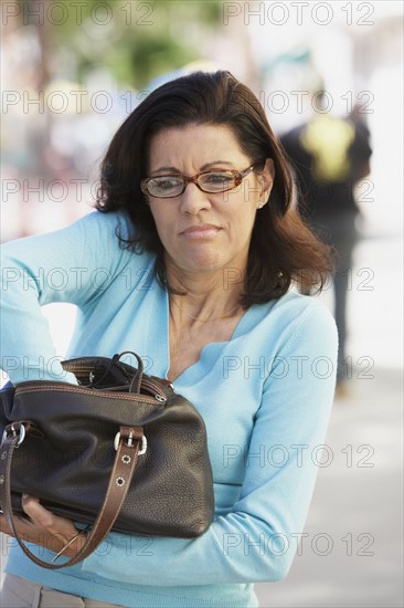 Middle-aged woman digging in her purse