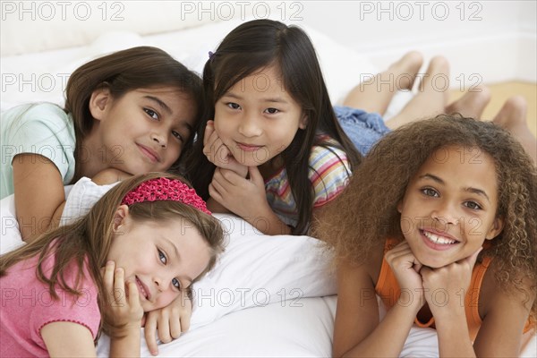 Group of young girls lying on bed