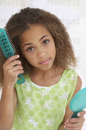 Young African American girl brushing hair