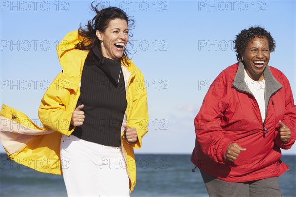 Two middle-aged women laughing outdoors