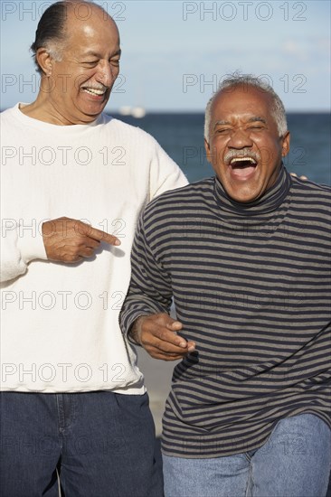 Two senior men laughing outdoors