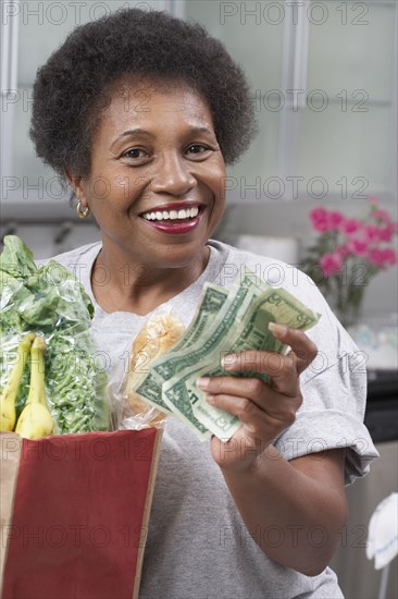 Senior African American woman with money and groceries