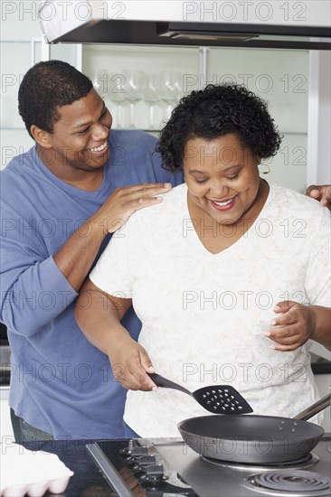 African couple cooking in kitchen