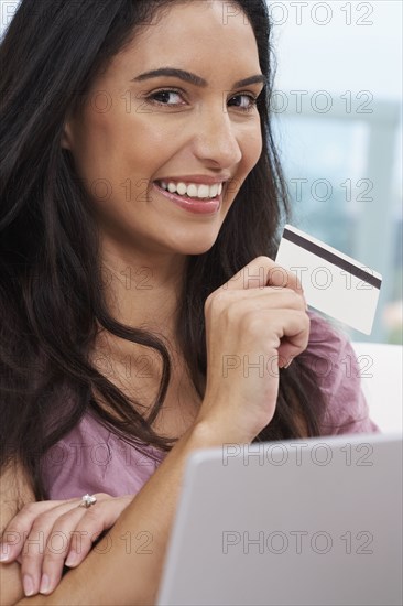 Hispanic woman holding credit card