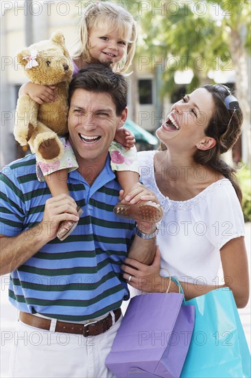 Hispanic family walking with shopping bags outdoors