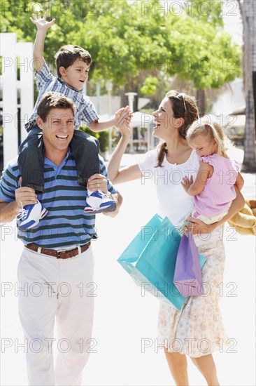 Hispanic family walking with shopping bags outdoors