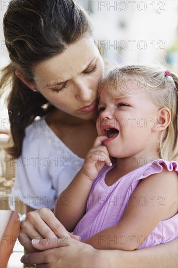 Hispanic mother comforting crying daughter