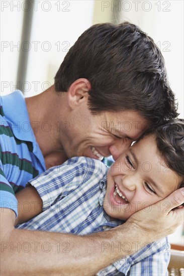 Hispanic father and son hugging