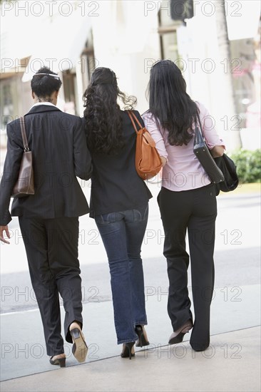 Multi-ethnic women walking on sidewalk