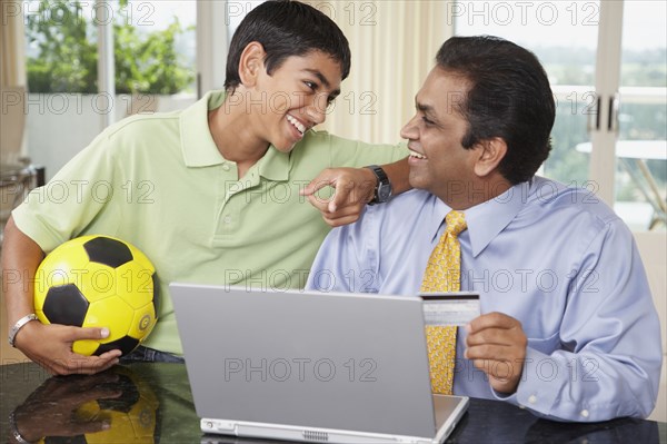 Middle Eastern father and son shopping online