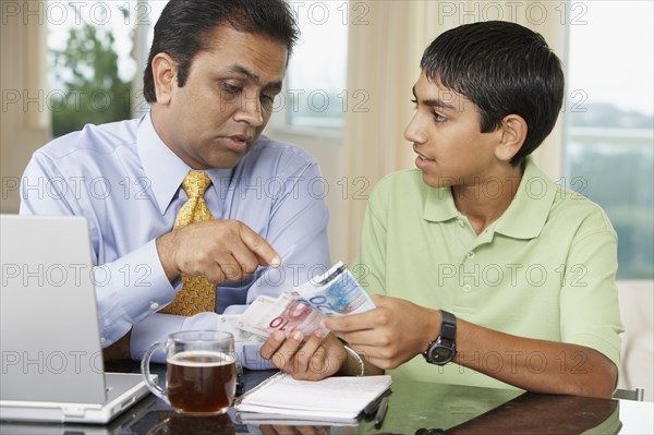 Middle Eastern father and son counting money