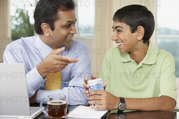 Middle Eastern father and son smiling at each other