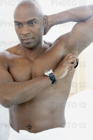 African American man putting on deodorant