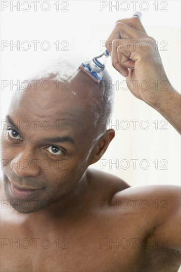 African American man shaving head