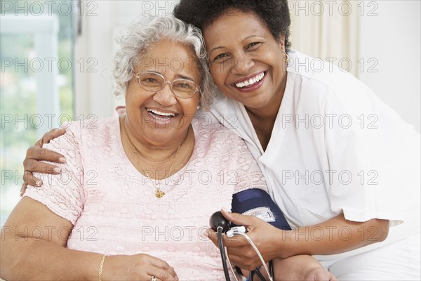 African American mother and adult daughter smiling at each other