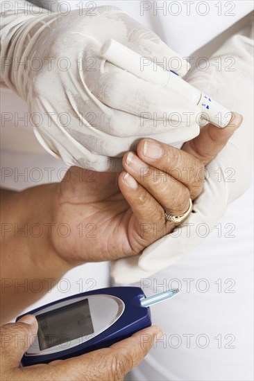 African American woman having blood sugar tested