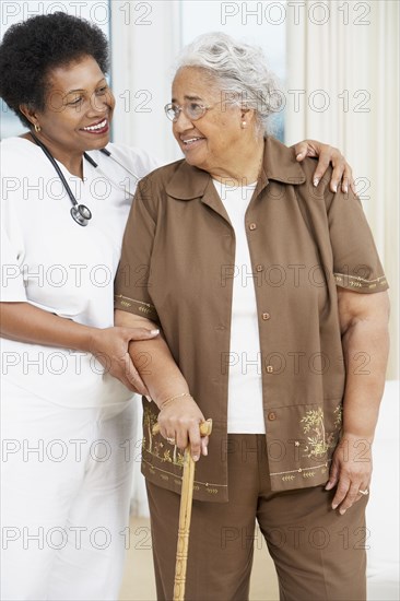 Doctor helping senior African American woman walk