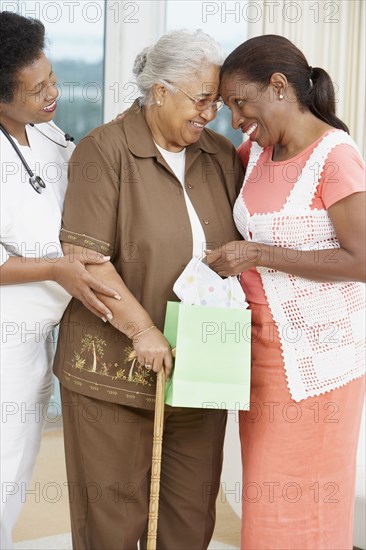 African American mother and adult daughter touching foreheads