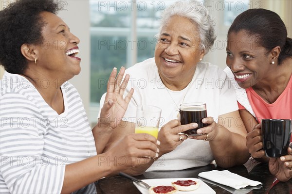 African American mother and adult daughters at breakfast