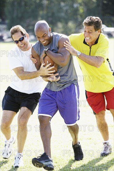 Multi-ethnic men playing football