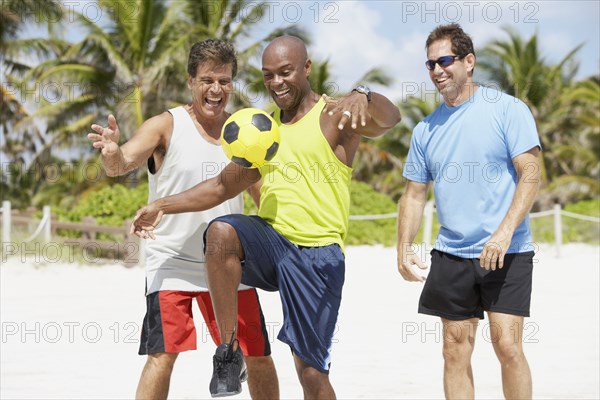 African American man bouncing soccer ball on knee