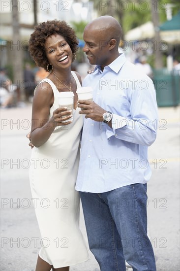 African American couple drinking take out coffee