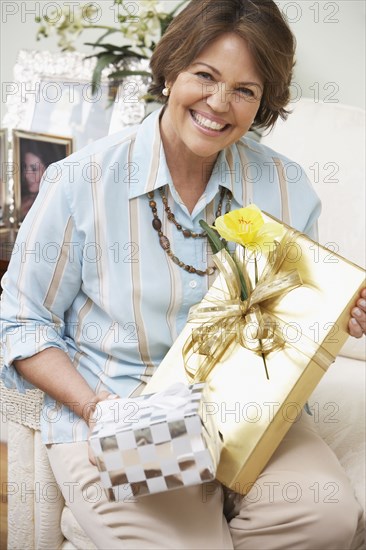 Senior Hispanic woman holding gifts