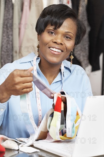 African fashion designer holding fabric swatches