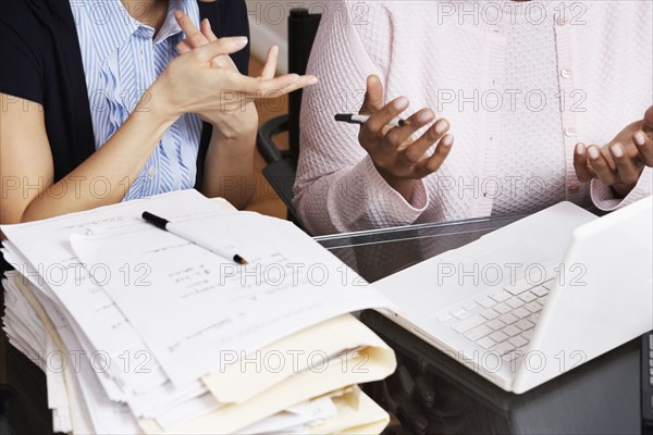 Multi-ethnic businesswomen with stack of folders