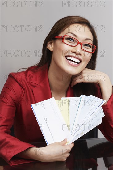 Asian businesswoman holding checks