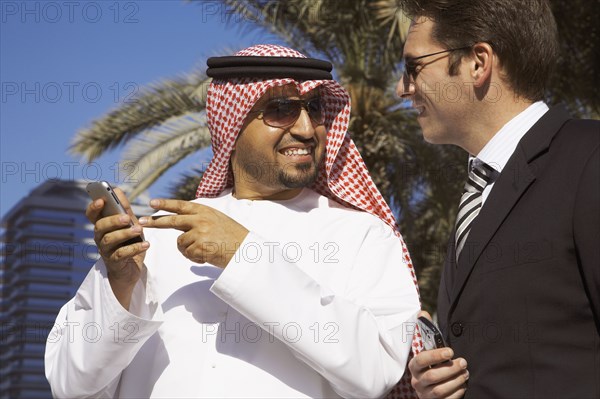 Multi-ethnic businessmen holding cell phones