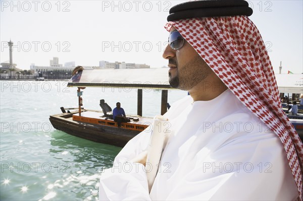 Arab man standing at waterfront