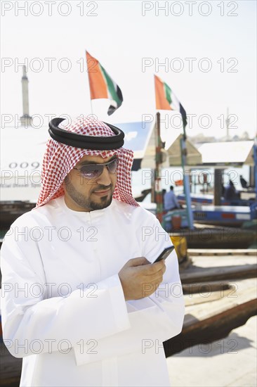 Arab man text messaging on cell phone