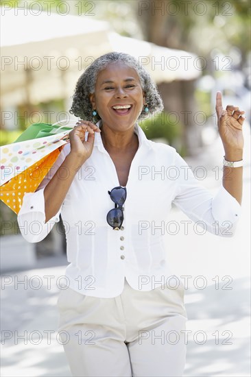 African woman carrying shopping bags and dancing
