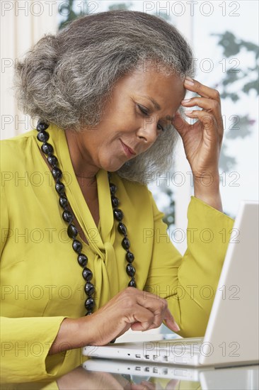 African woman using laptop at home