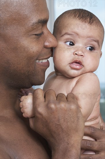 African father holding baby daughter