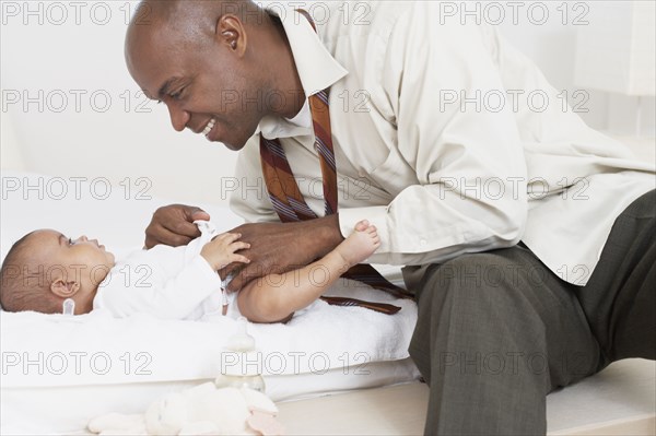 African father changing daughter's diaper