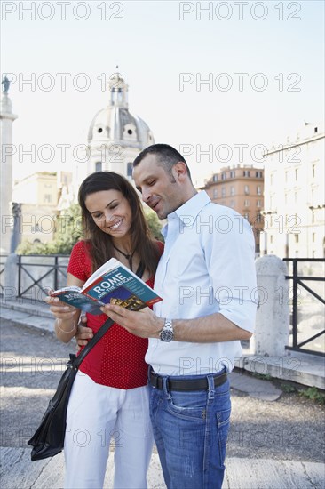 Tourists reading guidebook outdoors