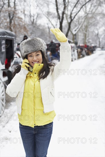 Korean woman talking on cell phone on snowy day