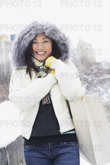 Korean woman walking with bag in snow