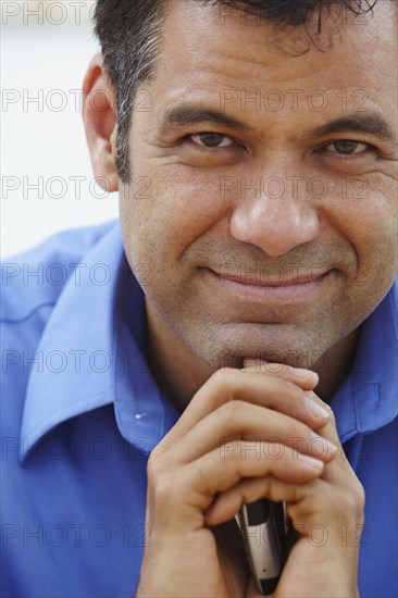 Close up of Hispanic businessman holding cell phone