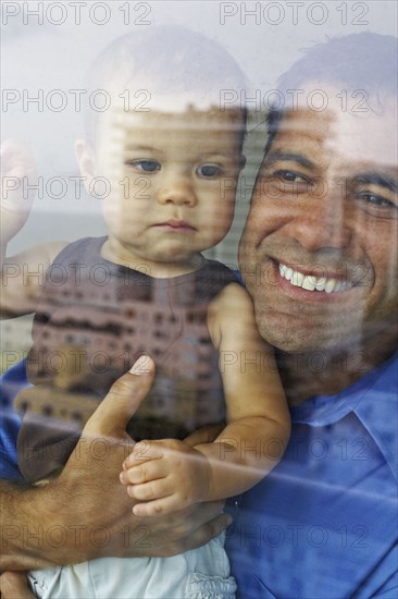 Hispanic father holding daughter