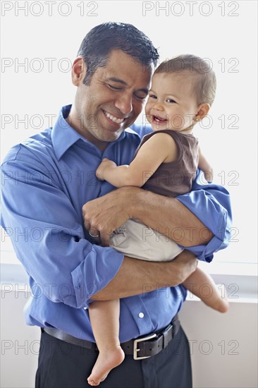 Hispanic father holding daughter