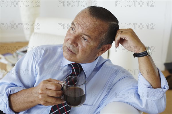 Hispanic businessman drinking coffee