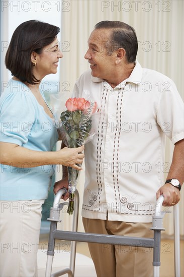 Hispanic woman bringing husband flowers