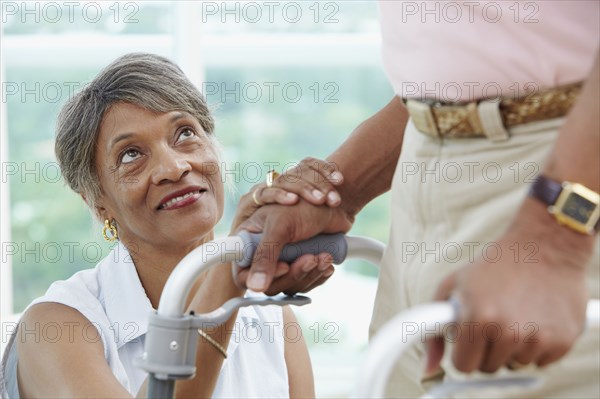African woman encouraging husband using walker