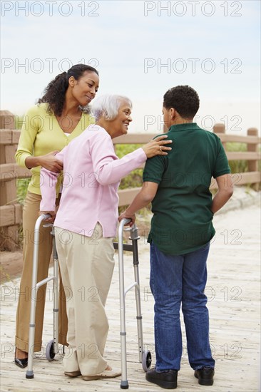 African American woman using walker with help of family