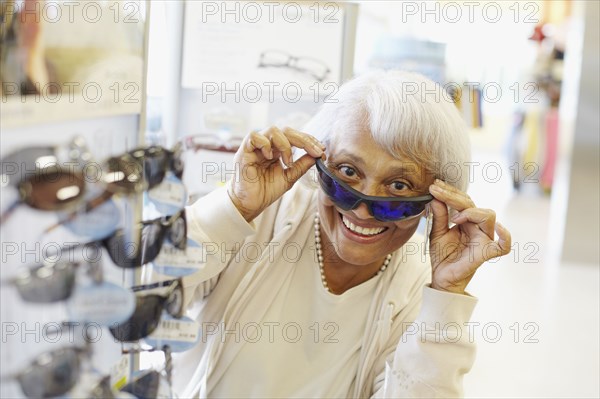 Senior African American woman trying on sunglasses