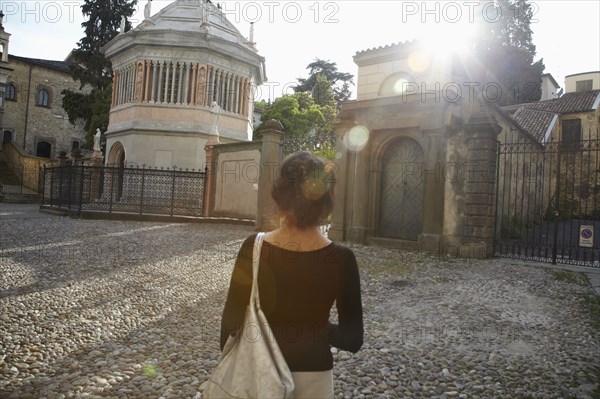 Italian woman standing near gates of building