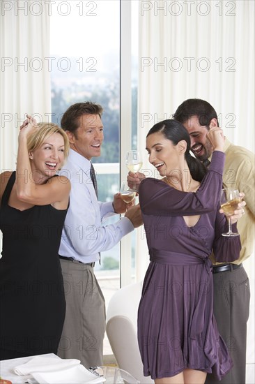 Two couples dancing together at party